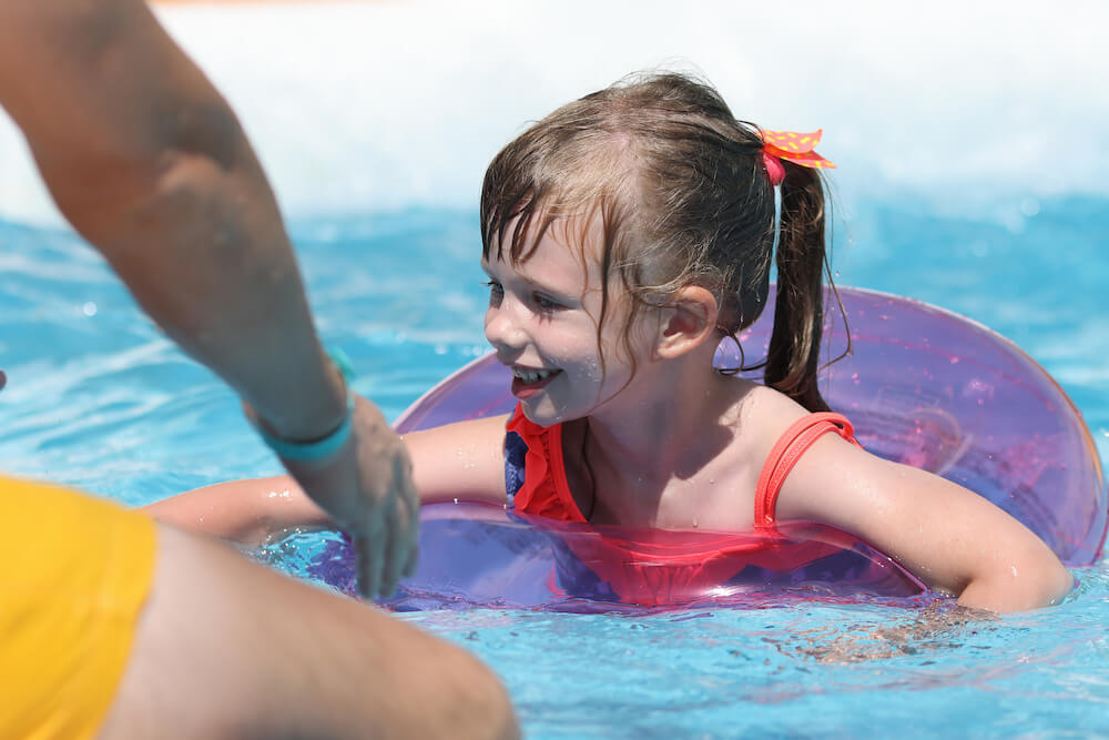 A little girl is enjoying in pool with safety